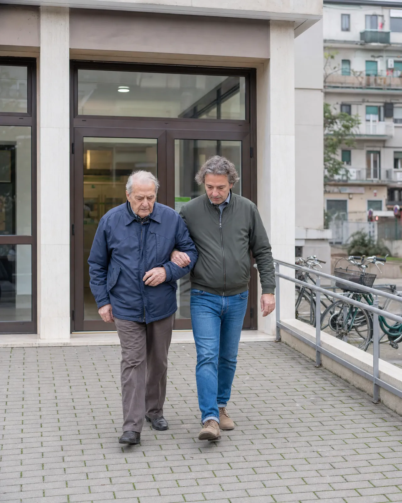 Uomo anziano cammina con un accompagnatore davanti a un ambulatorio di Padova