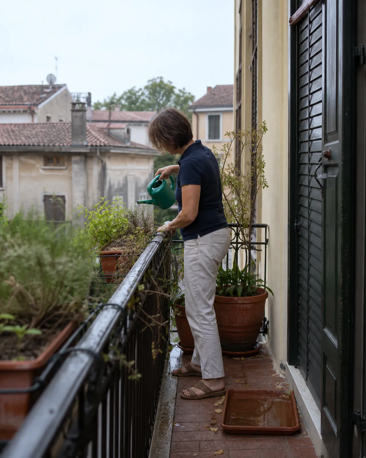 Donna innaffia le piante di una casa durante le vacanze a Padova