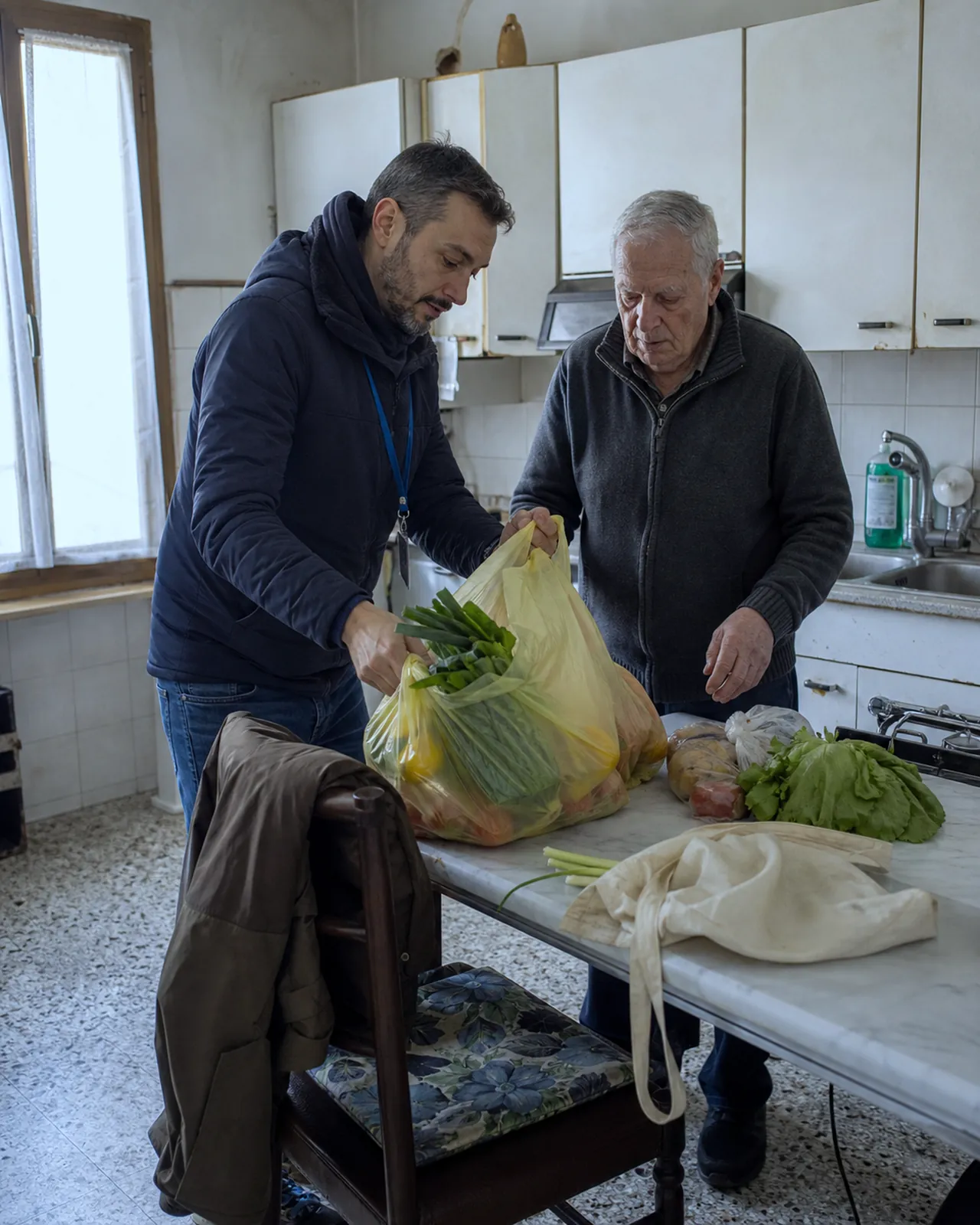 Persona porta la spesa a un uomo anziano nella sua casa a Padova