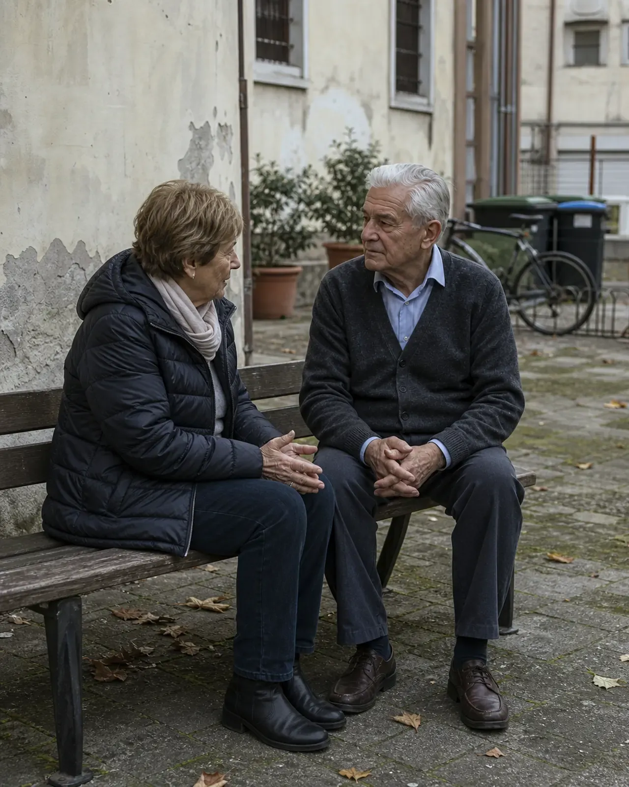 Anziano conversa con una vicina nel cortile di un condominio a Padova