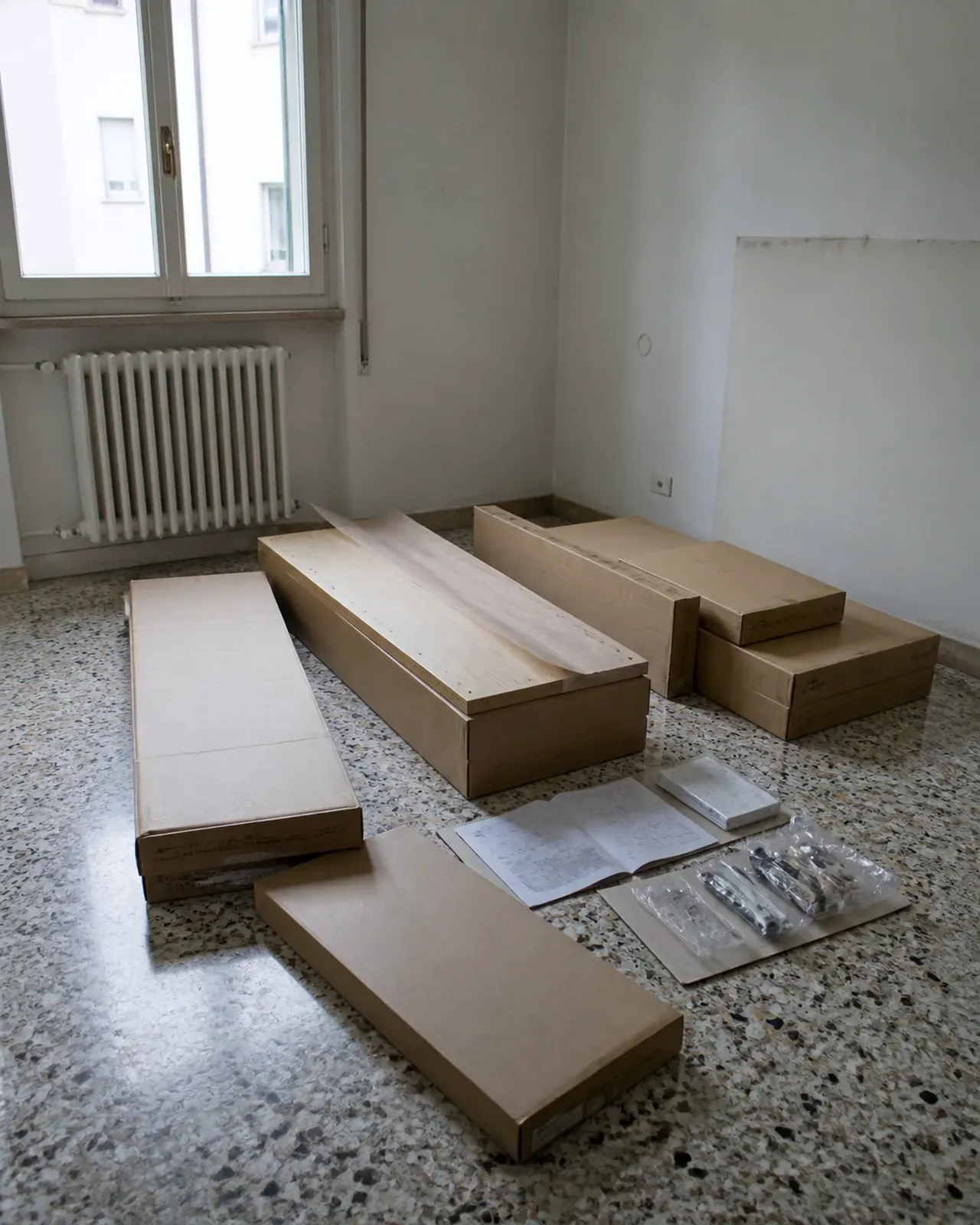 Scatole di mobili da montare in una stanza vuota di un appartamento a Padova